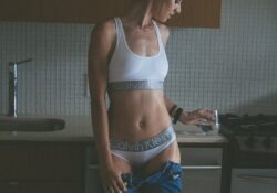 photo woman wearing white calvin klein brassiere and pantie holding a water glass in kitchen