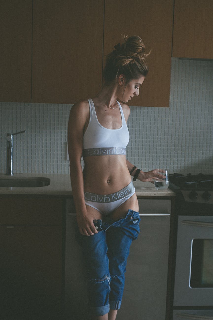 photo woman wearing white calvin klein brassiere and pantie holding a water glass in kitchen